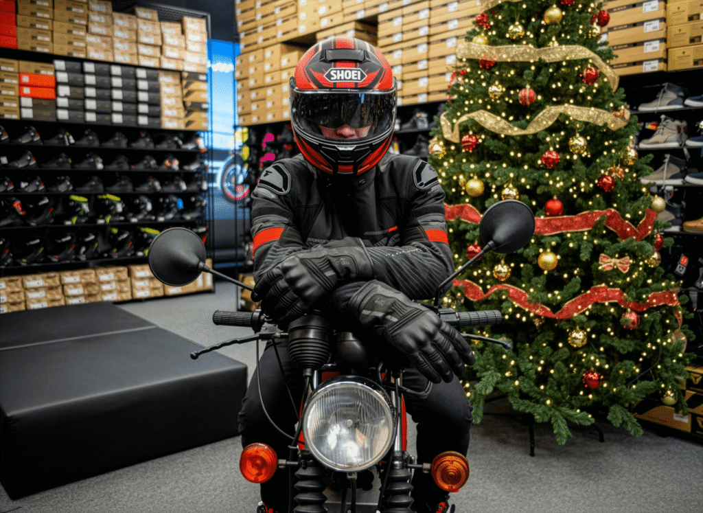 Motocyklista w kurtce motocyklowej Shima, w tle choinka bożonarodzeniowa
