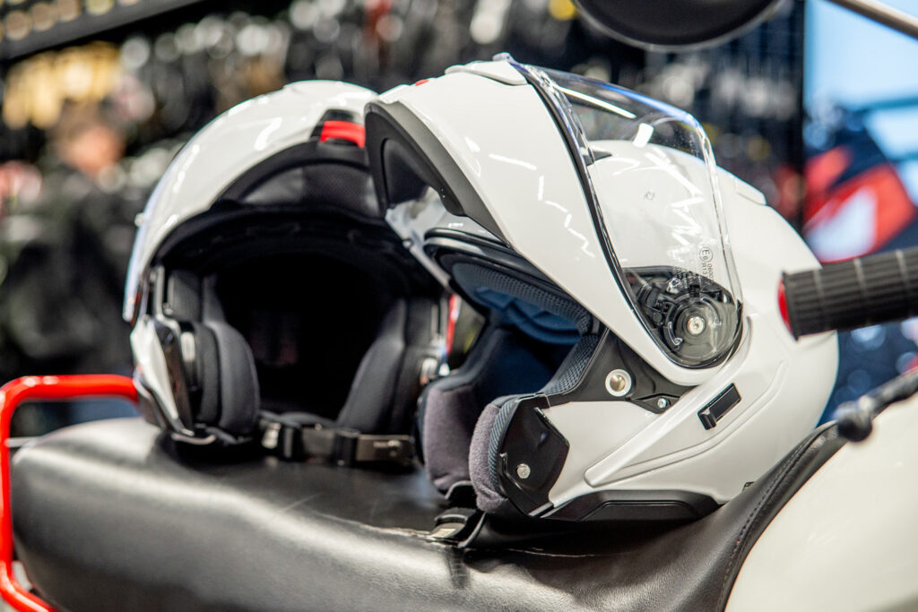 Kask motocyklowy Shoei Neotec 3 w kolorze białym, z podnoszoną szczęką i zintegrowaną blendą przeciwsłoneczną.